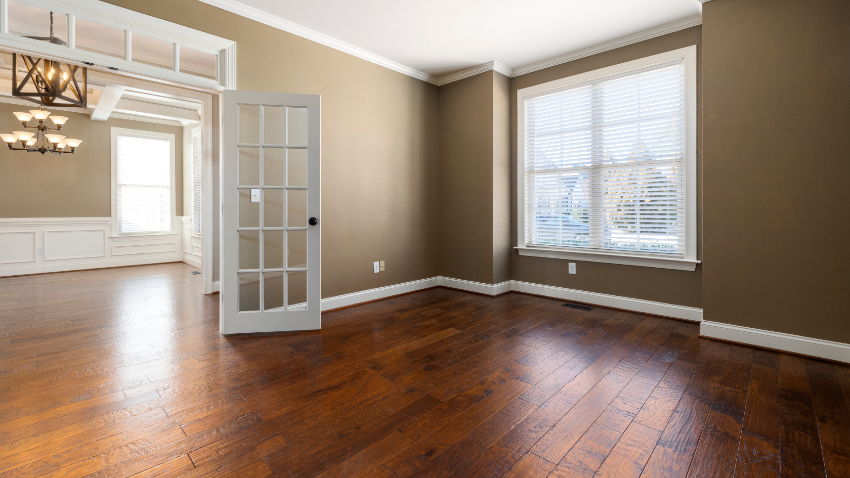 An empty room with hard wood floors and a white door