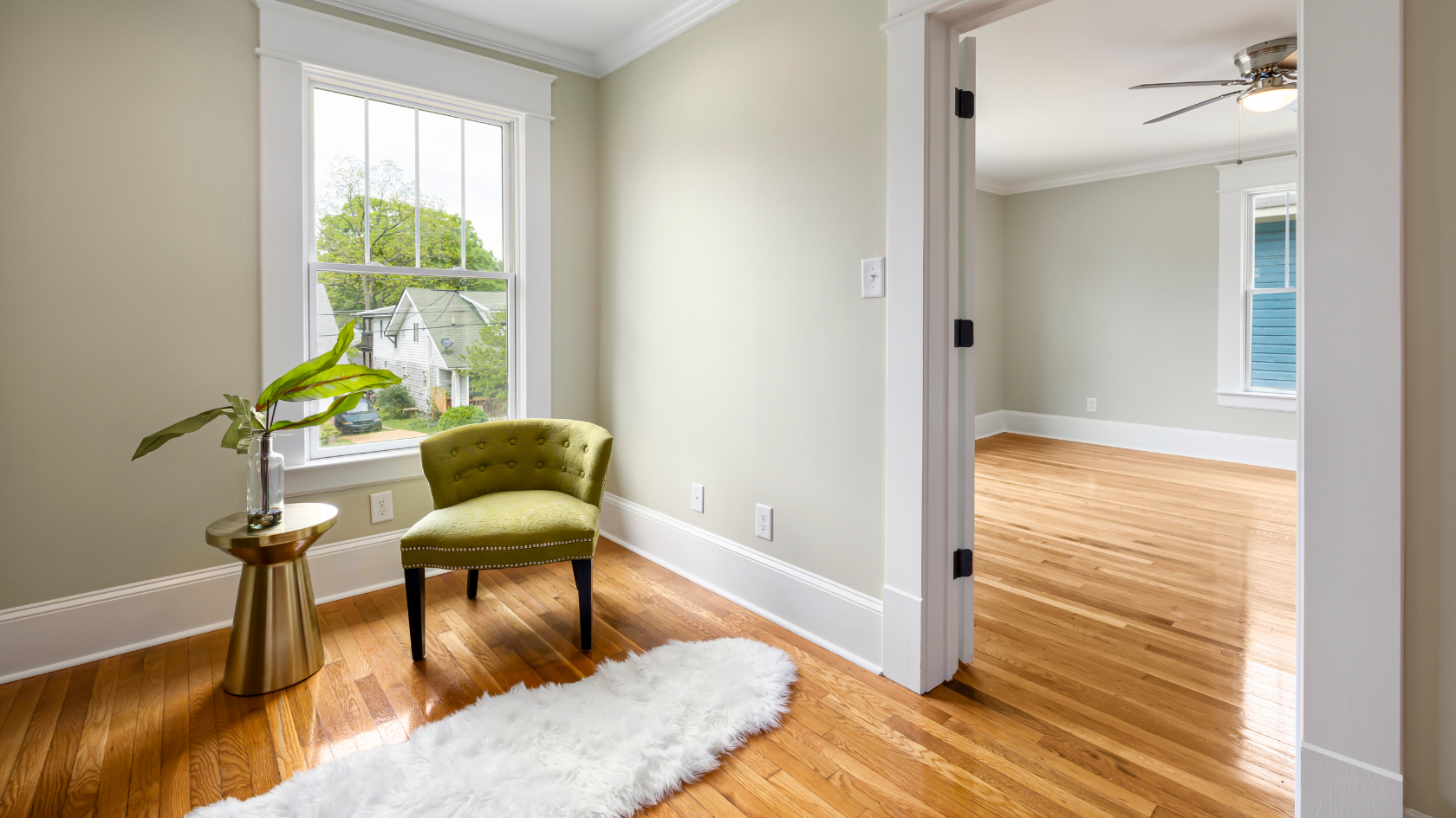 A green chair sitting in a living room next to a window