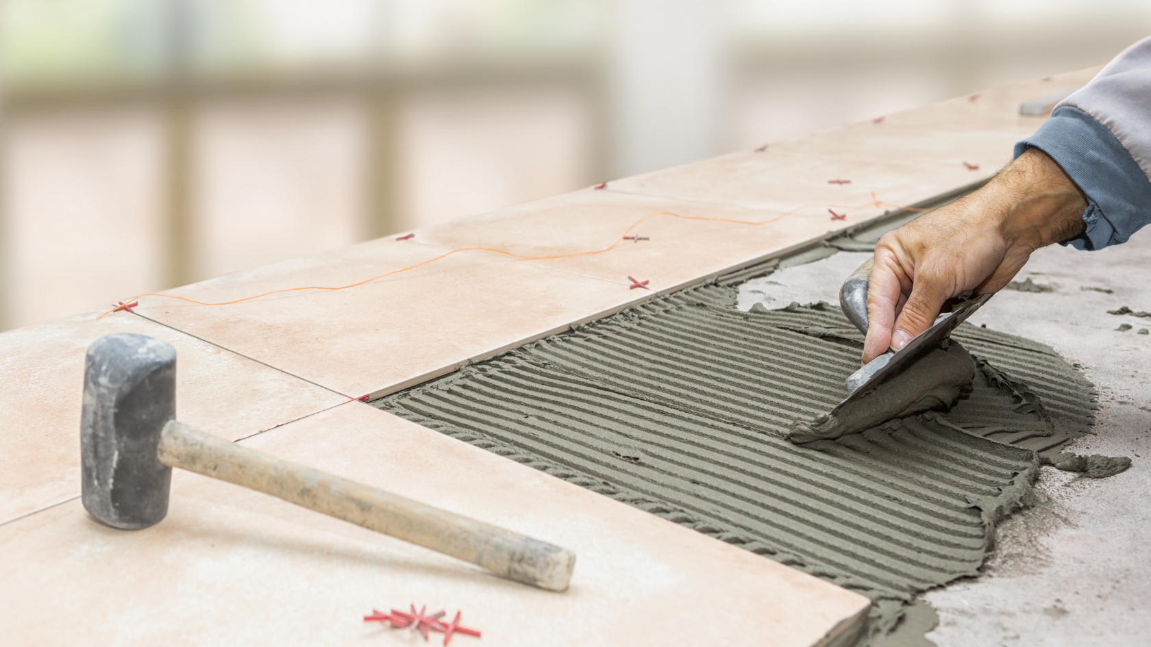 A person using a tile cutter on a floor